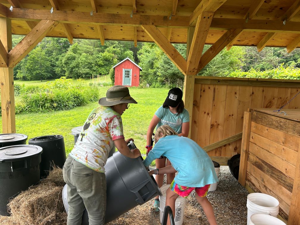 Buxton and two students working with compost