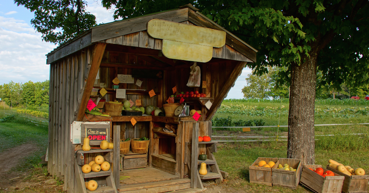 An outdoor farmstand with a variety of vegetables.