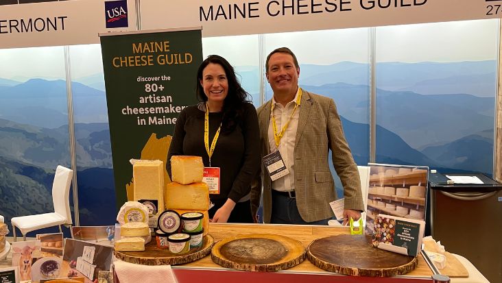Two happy vendors displaying cheese at SIAL, Canada.