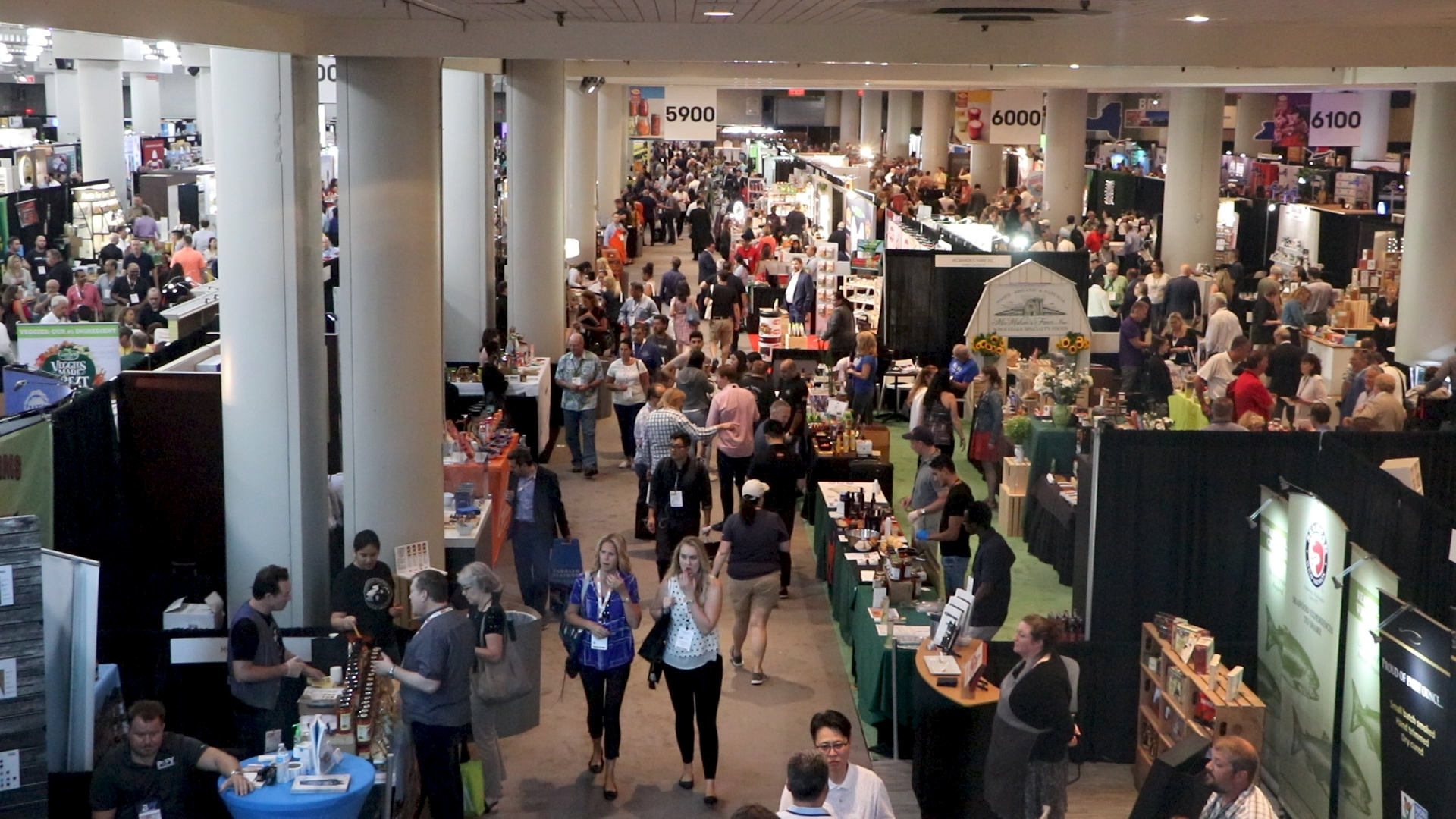 A large crowd walking by booths at the Summer Fancy Food Show.