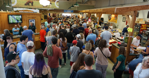 A large crowd walks through the Vermont Building at the Big E