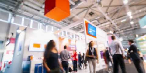 a group of people walking around a trade show