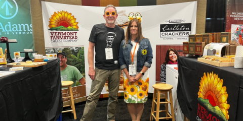 Two people standing in a trade show booth with sunflower product marketing