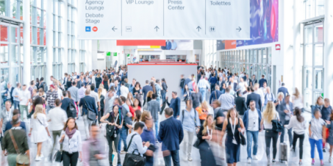 A large crowd walking through a trade show