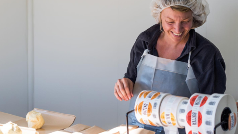 Ploughgate employee places stickers on packaged butter