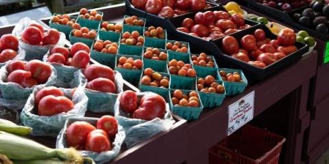 A photo of sweet corn and tomatoes on display at a farm stand